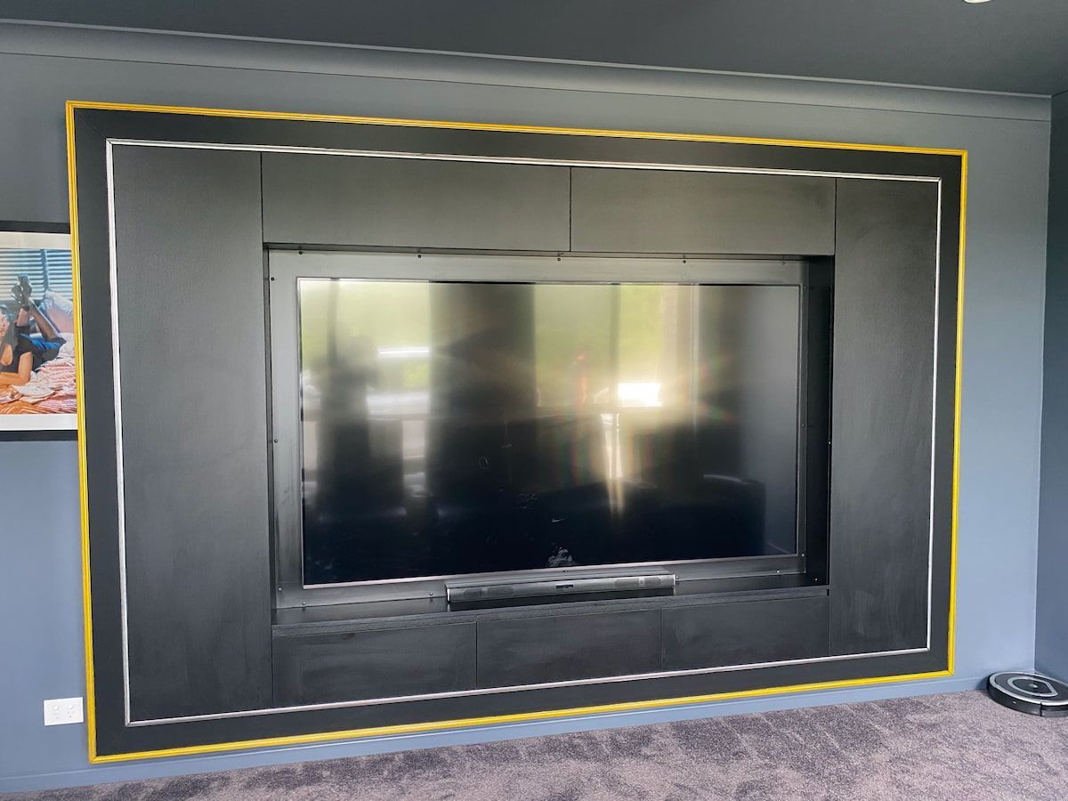 A Large Flat Screen Tv Is Mounted on A Wall in A Living Room — Simonetto'S Cabinets & Joinery in Maroochydore, QLD