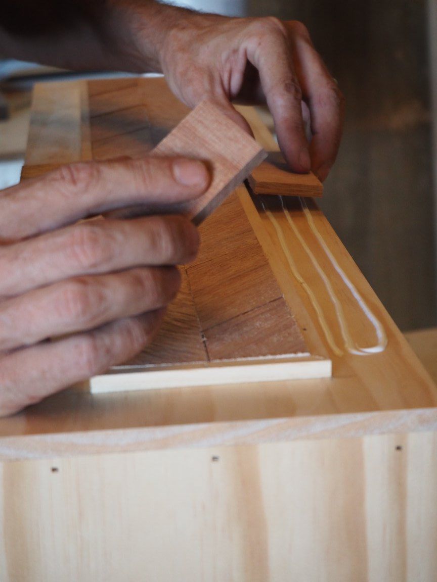 A Person Is Gluing a Piece of Wood to A Piece of Wood — Simonetto'S Cabinets & Joinery in Buderim, QLD