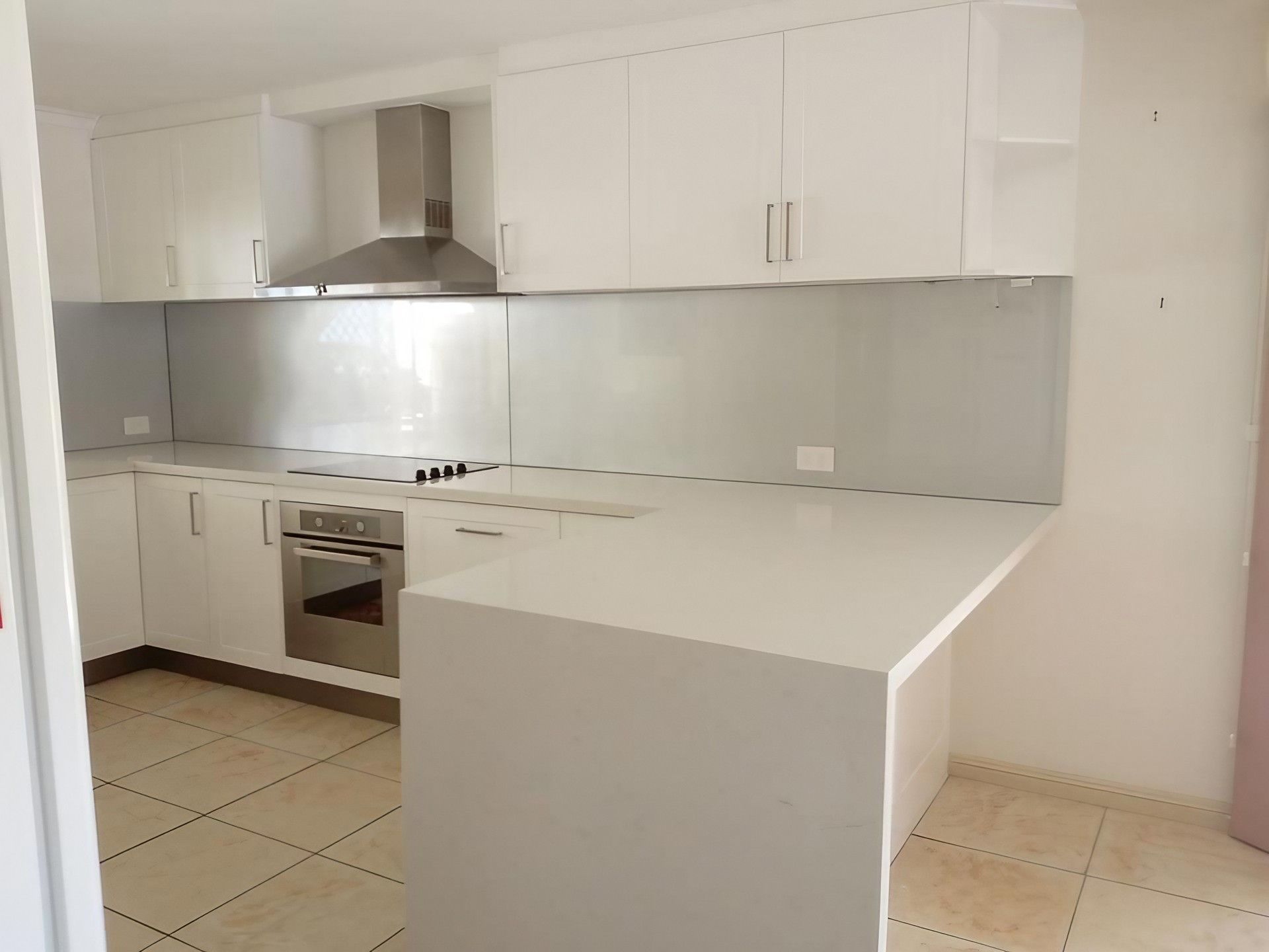 An Empty Kitchen With White Cabinets and Stainless Steel Appliances — Simonetto'S Cabinets & Joinery in Nambour, QLD