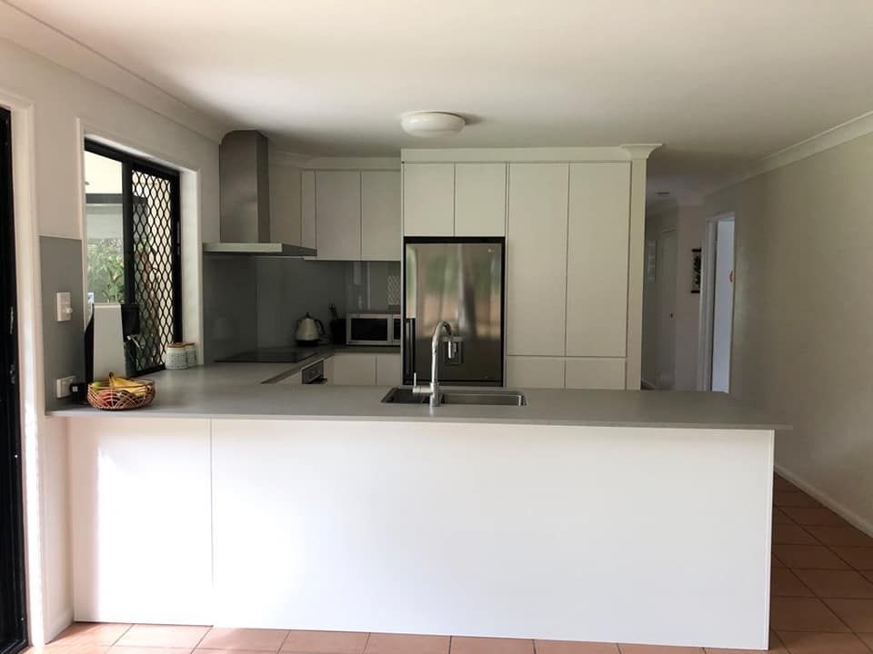 A Kitchen with White Cabinets, a Sink, and A Refrigerator — Simonetto'S Cabinets & Joinery in Nambour, QLD