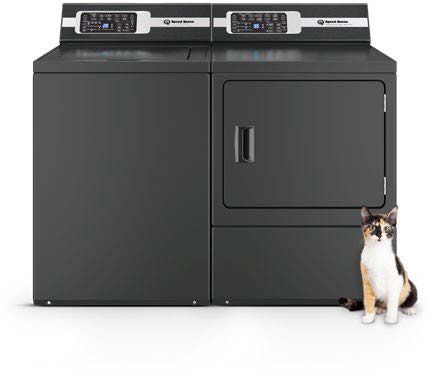 A cat is sitting next to a black Speed Queen washer and dryer.