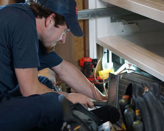 a trilakes appliance repair tech makes a repair on a subzero brand refrigerator