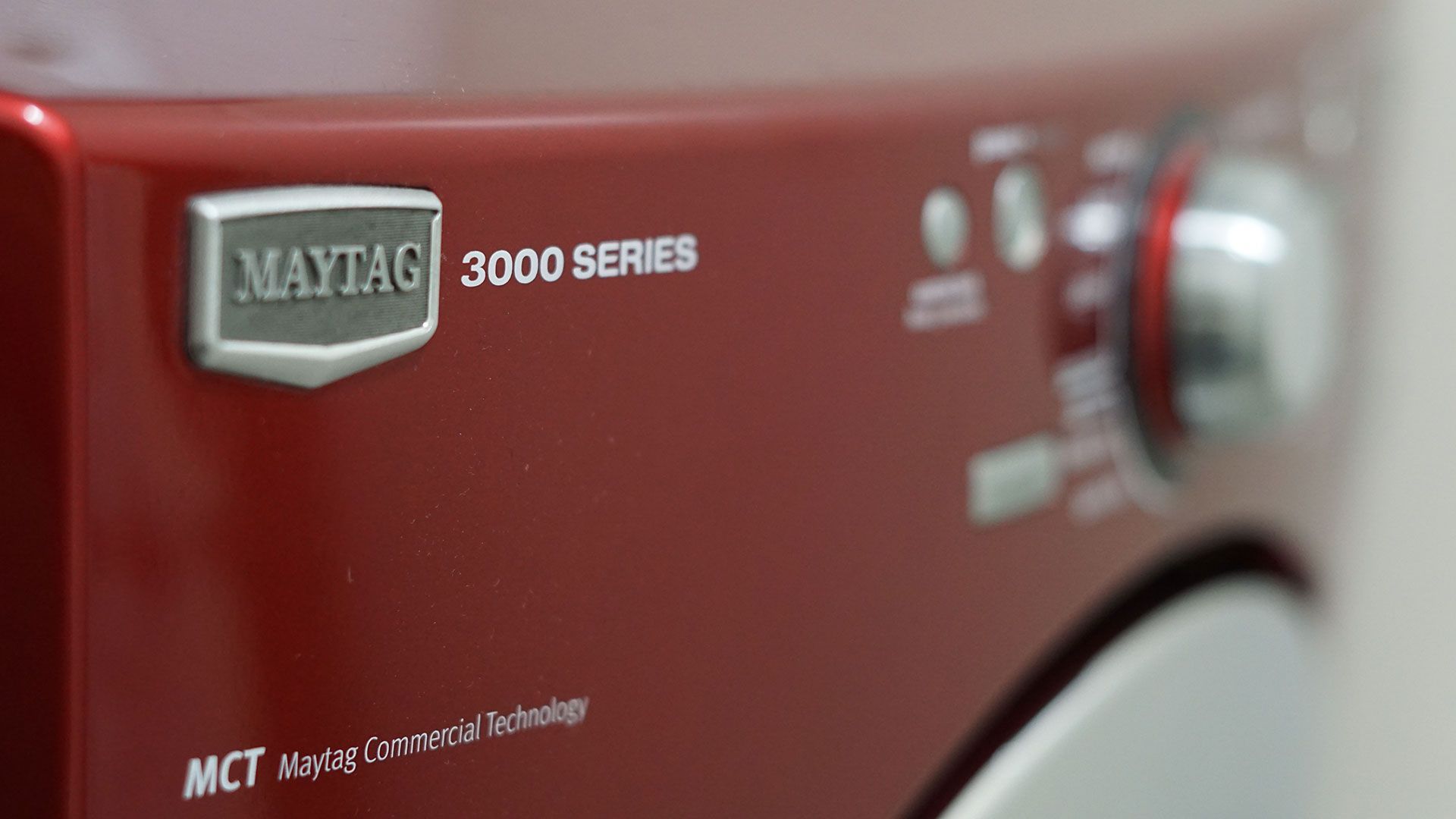 A red maytag washer and dryer is sitting on a white surface.