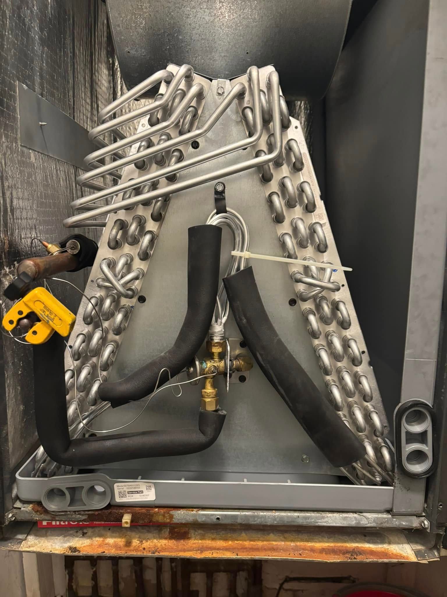 A close up of a refrigerator with a lot of pipes coming out of it.