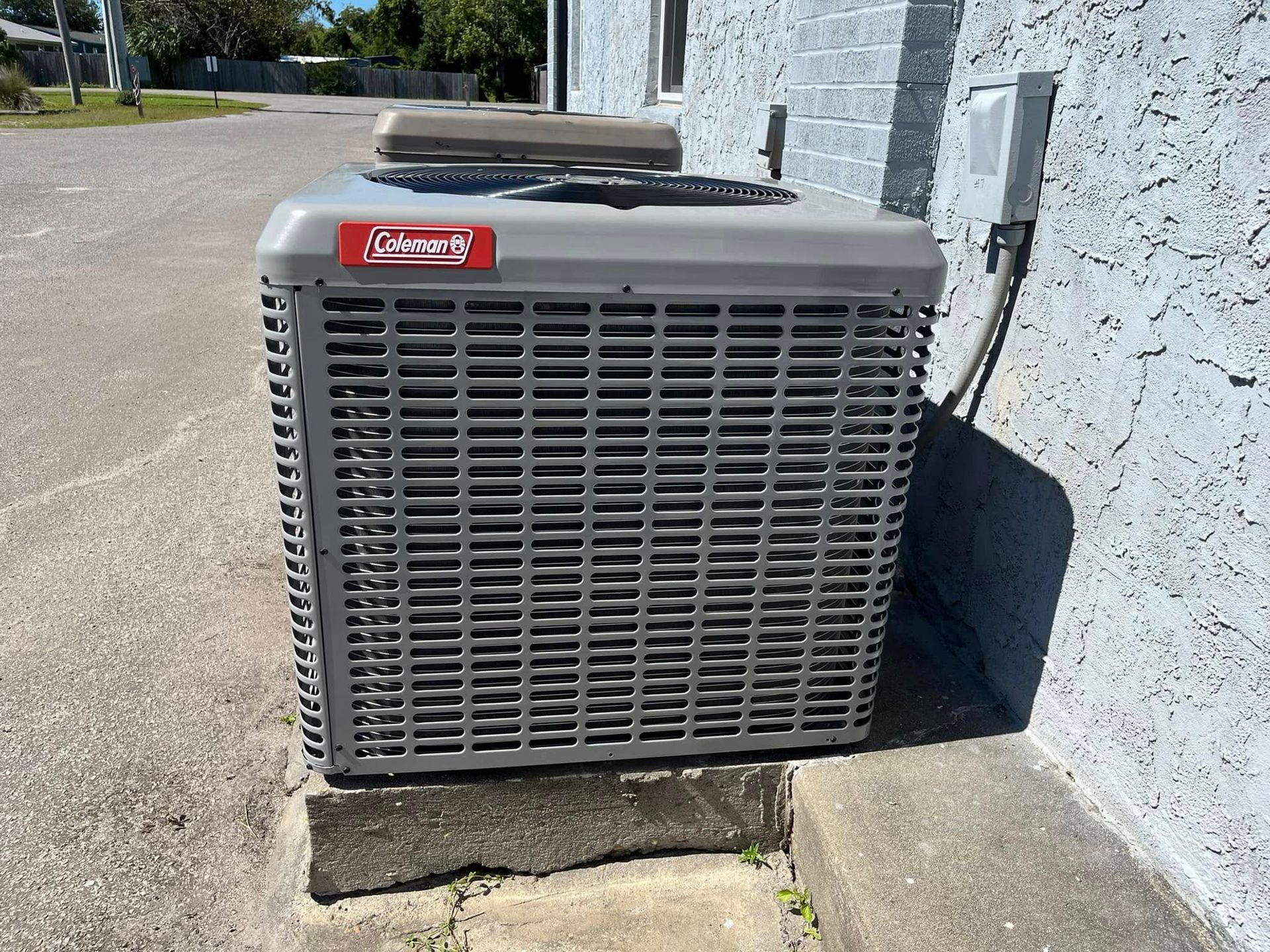 An air conditioner is sitting on the side of a building.