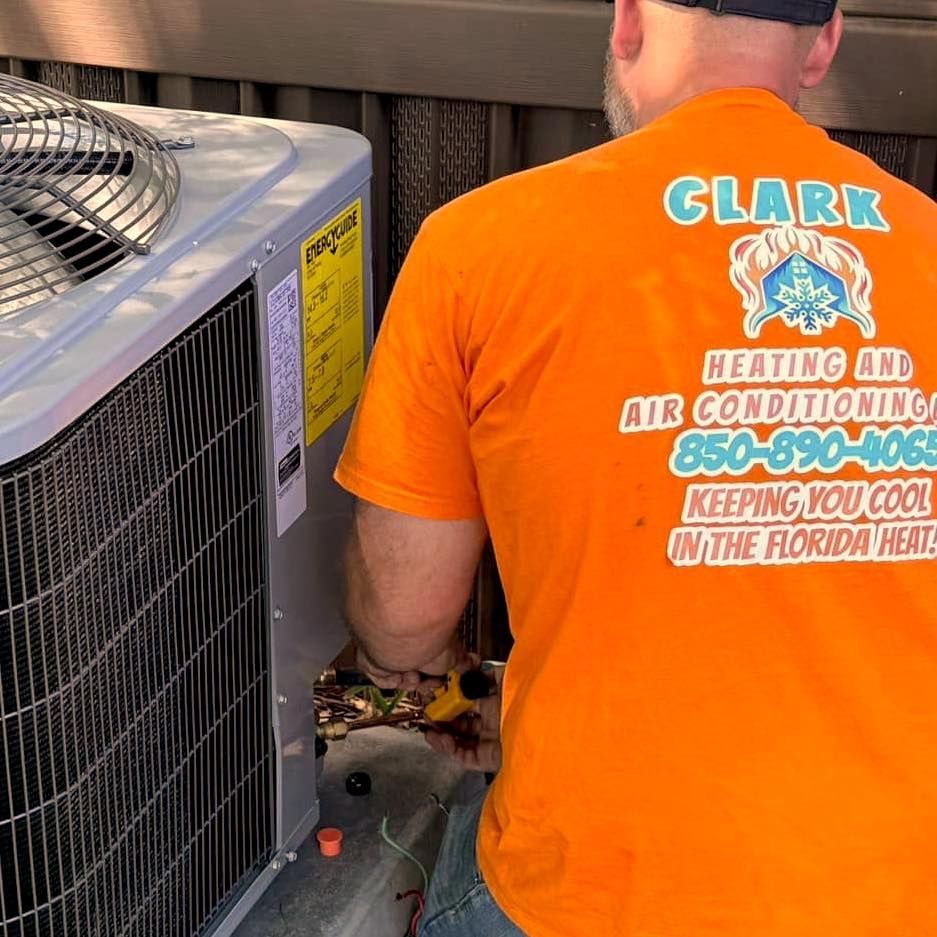 A man wearing an orange shirt that says clark heating and air conditioning