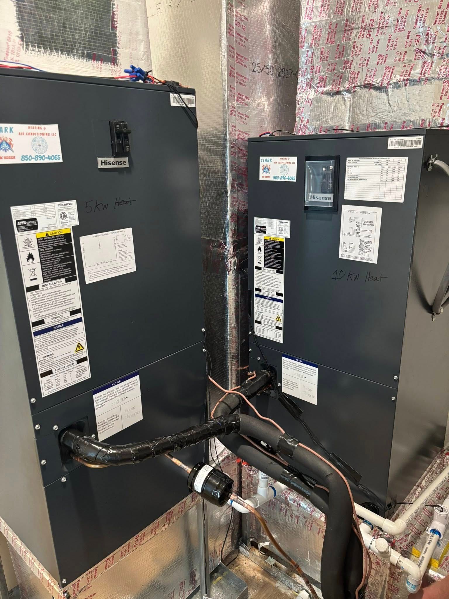 Two air conditioners are sitting next to each other in a room.