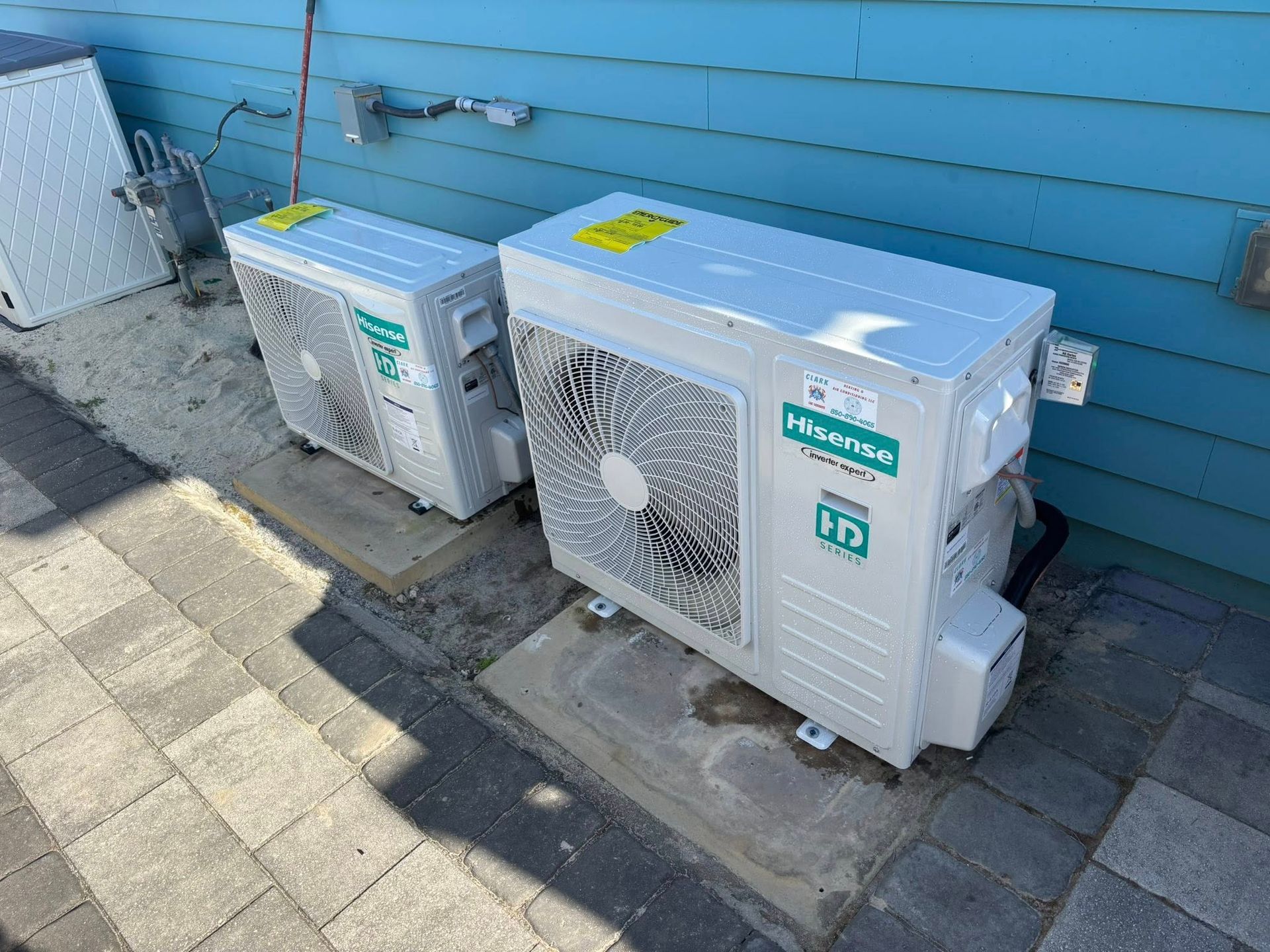 Two hisense air conditioners are sitting on the side of a building.
