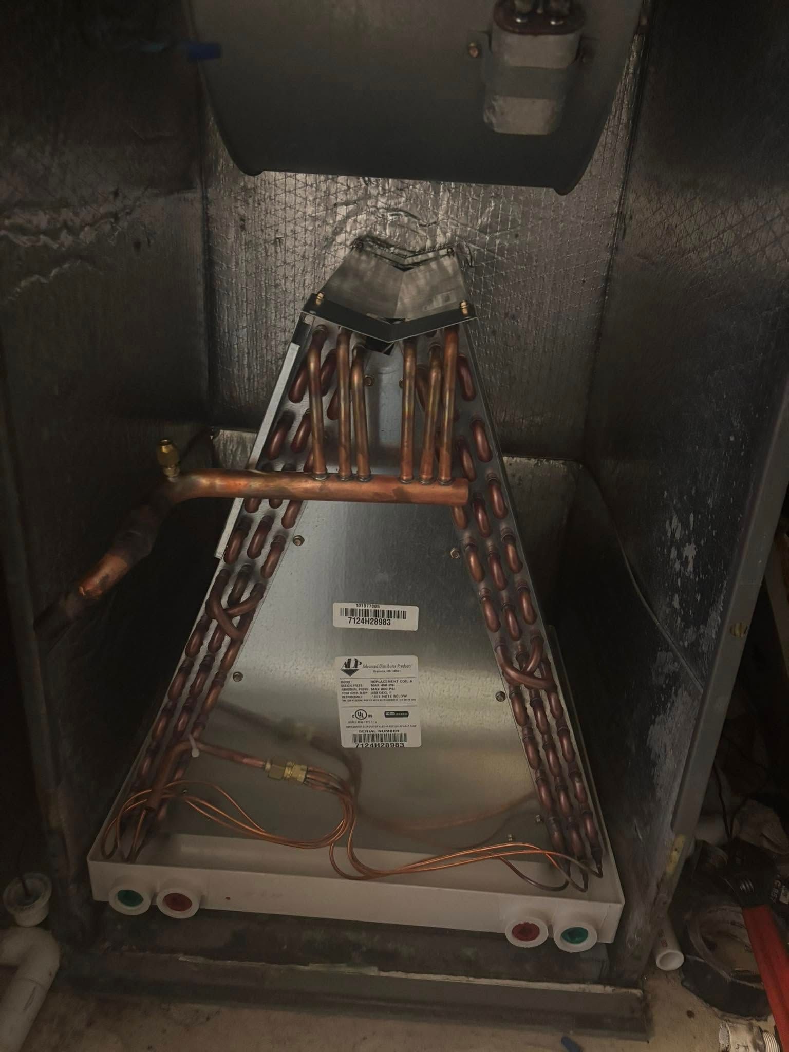 A copper pipe is sitting inside of a metal box.