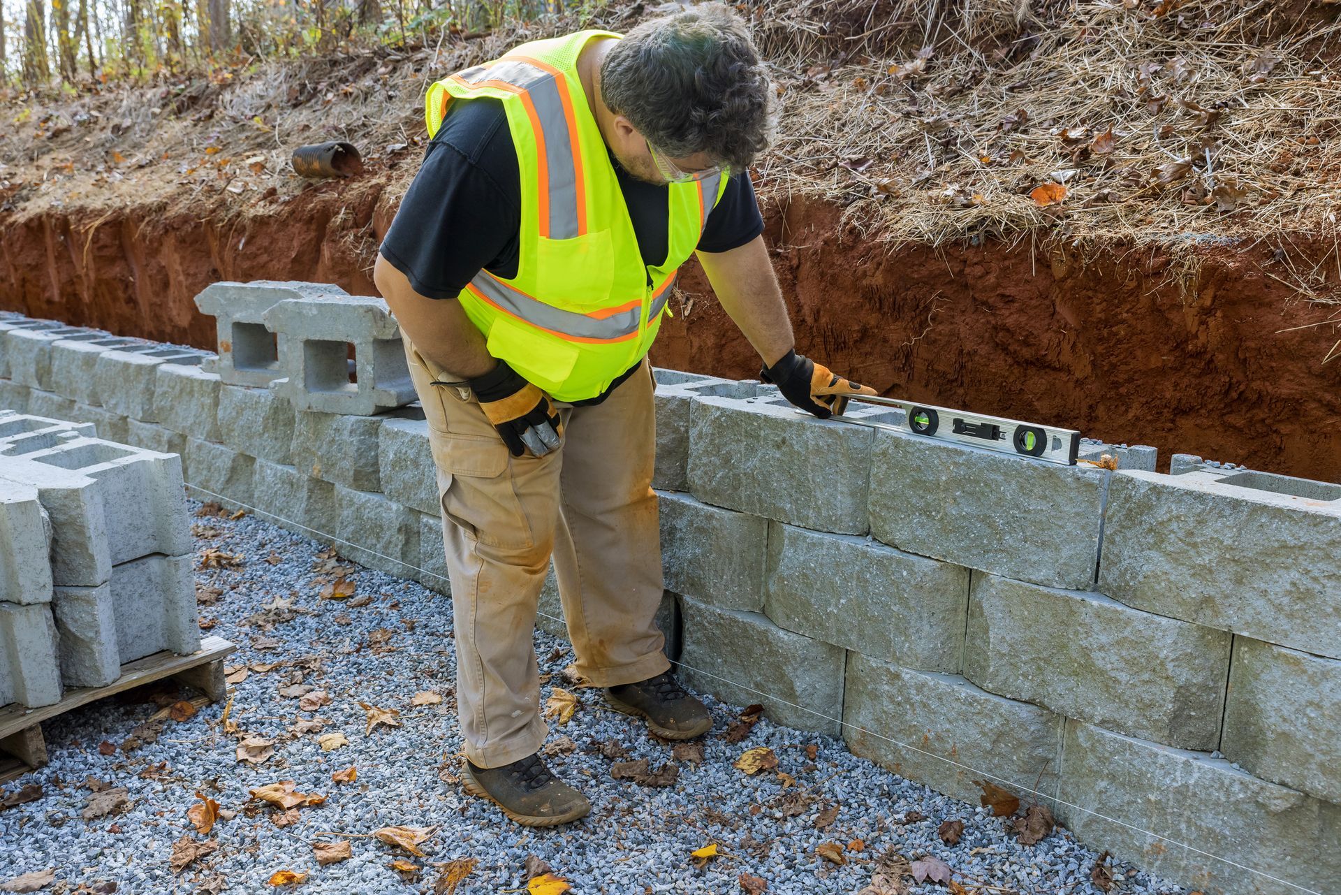 A Construction Worker Is Measuring A Brick Wall With A Level | Newark, NJ | Leon Brothers