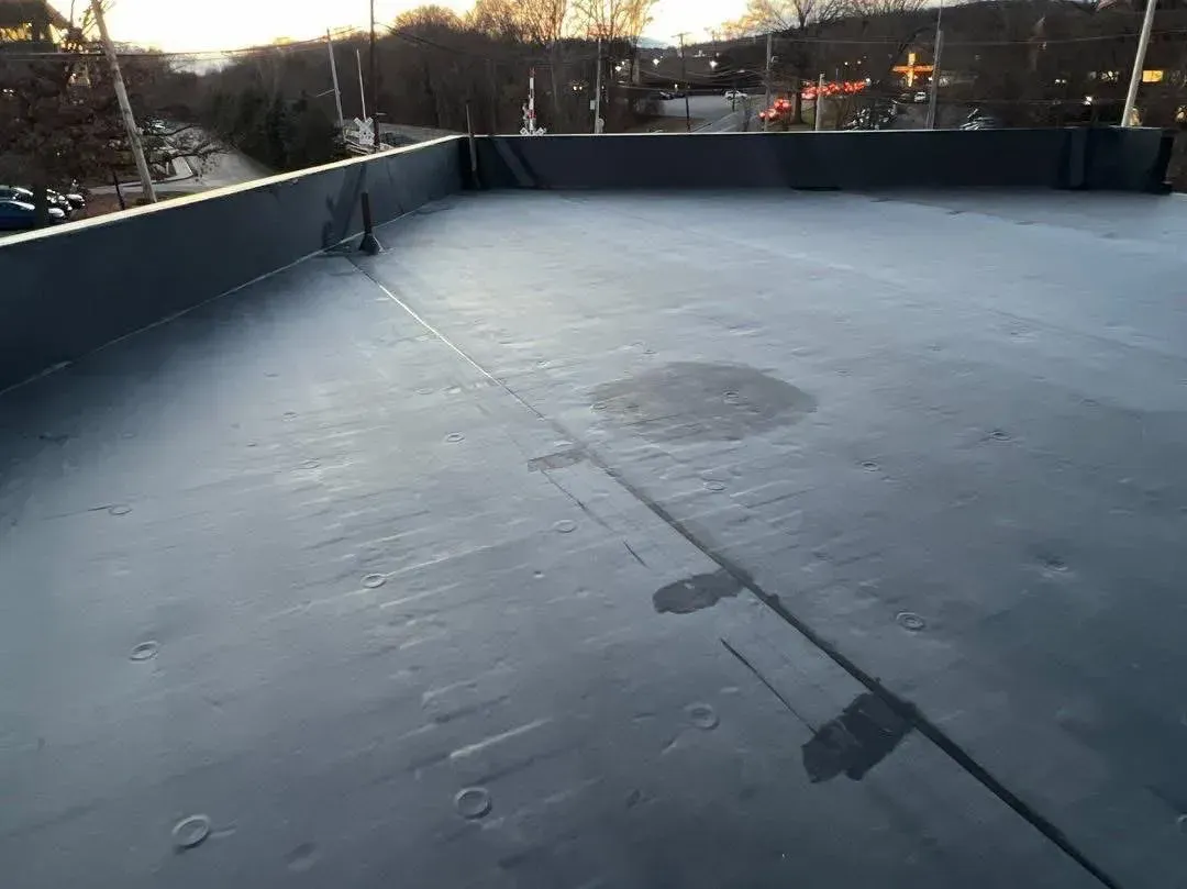 A man is working on a roof with a hammer.