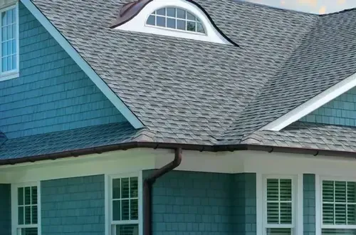 A blue house with a gray roof and white windows