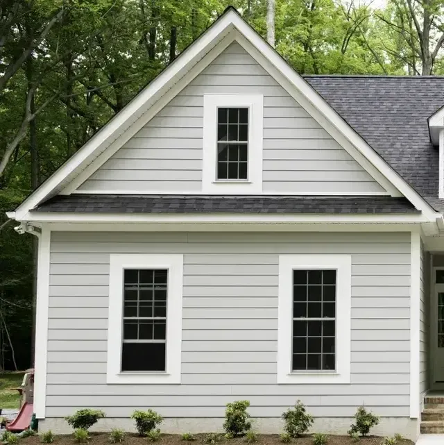 A white house with black windows and a gray roof