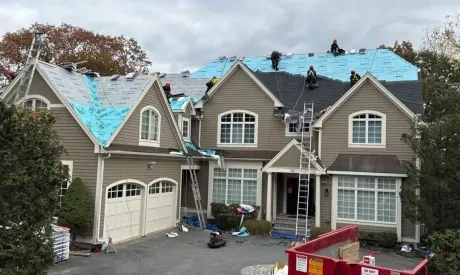 A man is working on a roof with a drill.