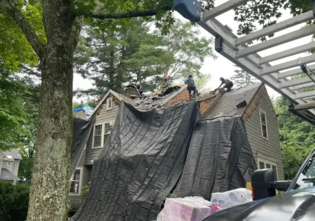 A man is working on a roof with a hammer.