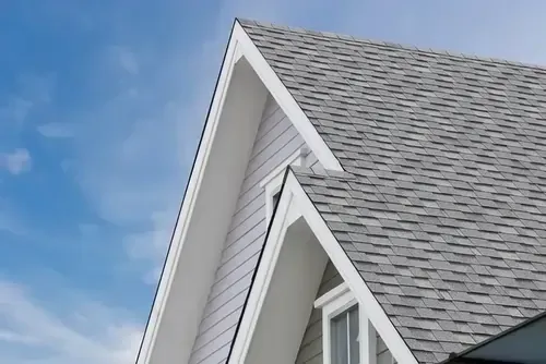A house with a gray roof and a blue sky in the background