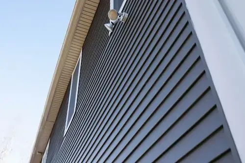 The side of a house with a gray siding and white trim