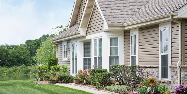 A large house with a lot of windows and flowers in front of it.