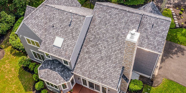An aerial view of a large house with a gray roof.