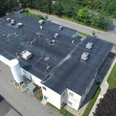 An aerial view of a large building with a black roof