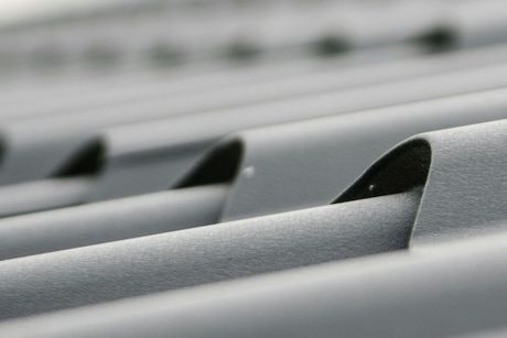 A close up of a metal roof with a few holes in it.