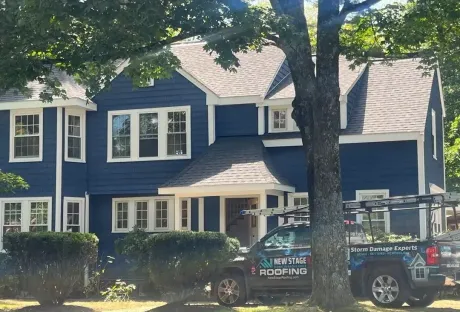 The side of a house with a gray siding and white trim
