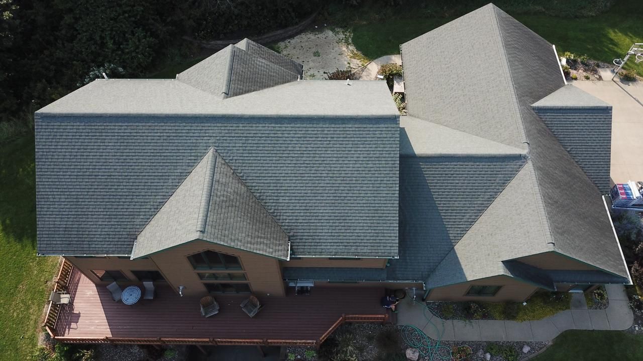 An aerial view of a large house with a gray roof