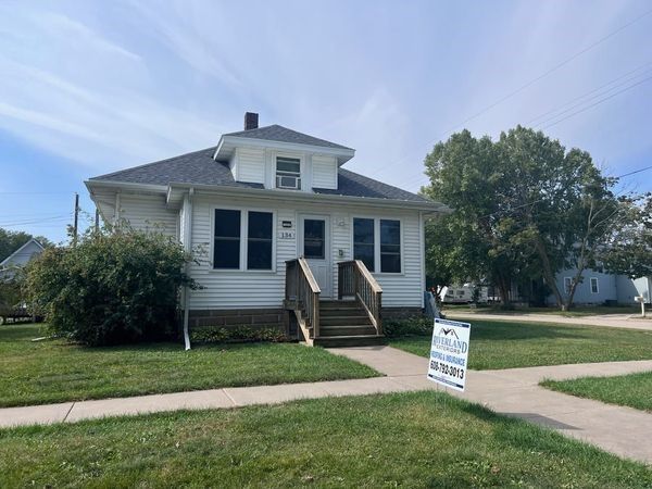 A white house with a for sale sign in front of it — Holmen, WI — Riverland Exteriors Corporation