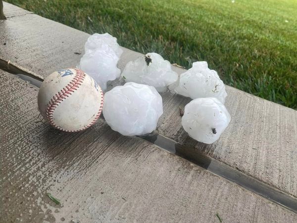A baseball and hail are sitting on a bench — Holmen, WI — Riverland Exteriors Corporation
