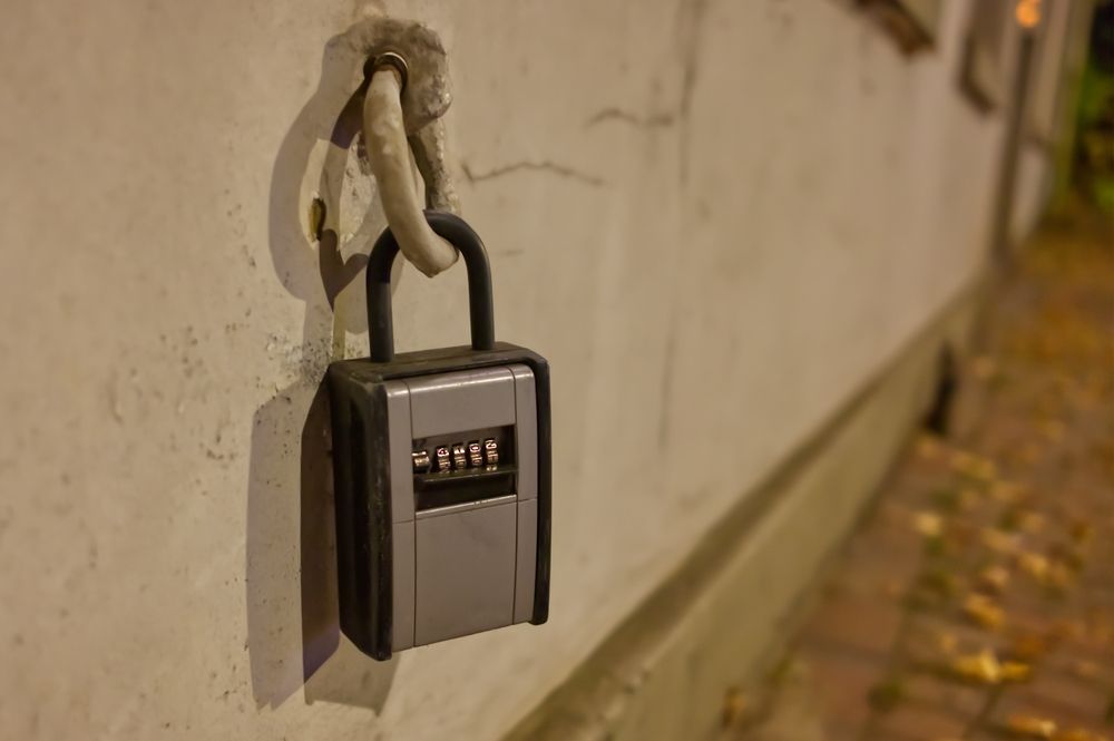 A padlock is hanging on a white wall.