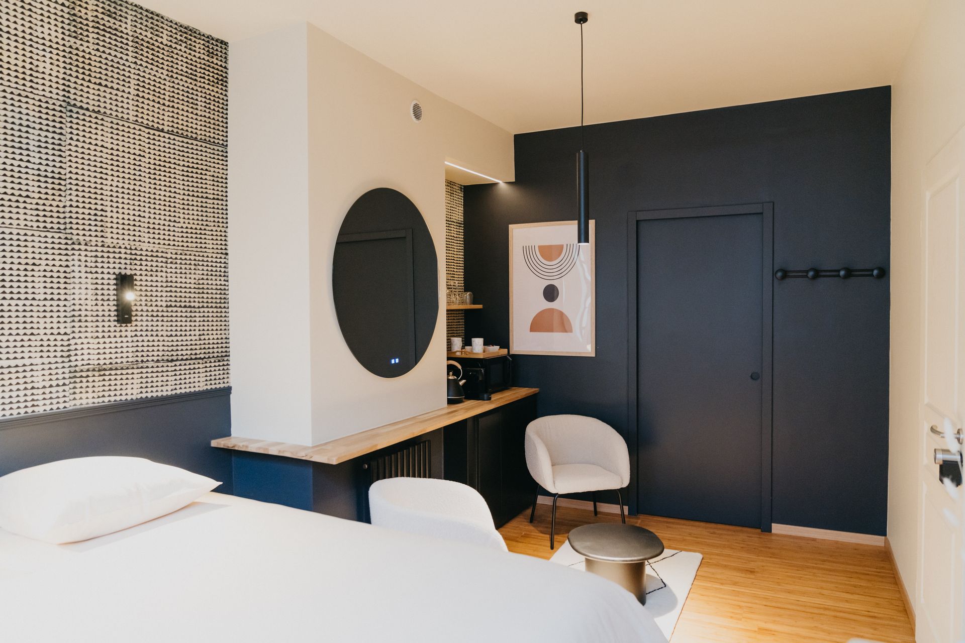 Une chambre d'hôtel avec un lit, une chaise, une table et un miroir.