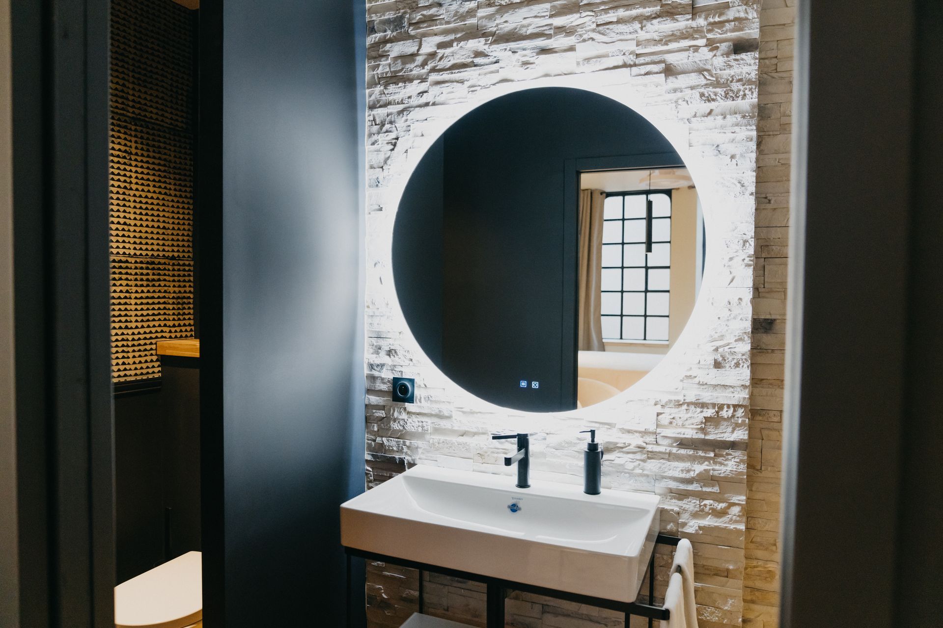 Une salle de bain avec lavabo, miroir et WC.
