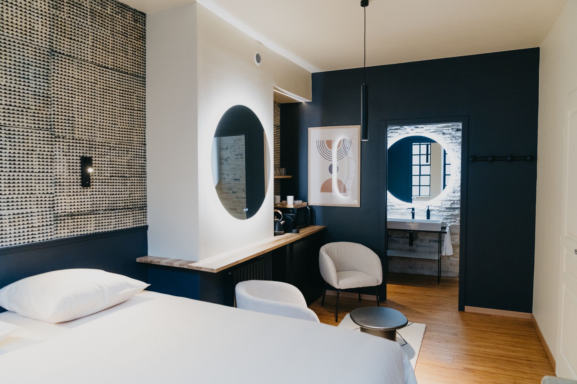 Une chambre d'hôtel avec un lit, des chaises, une table et un miroir.