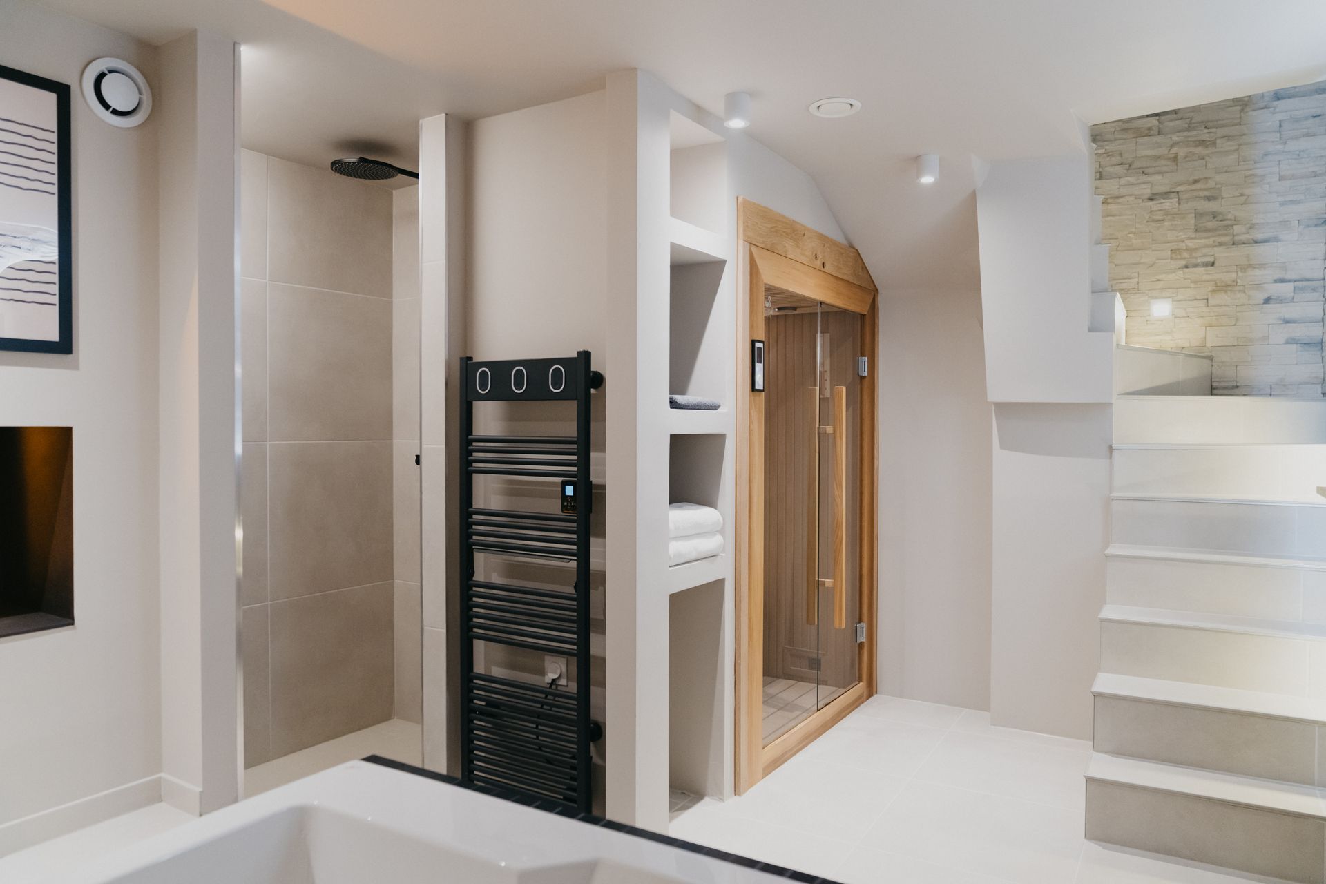 Une salle de bain avec baignoire, douche et sauna.