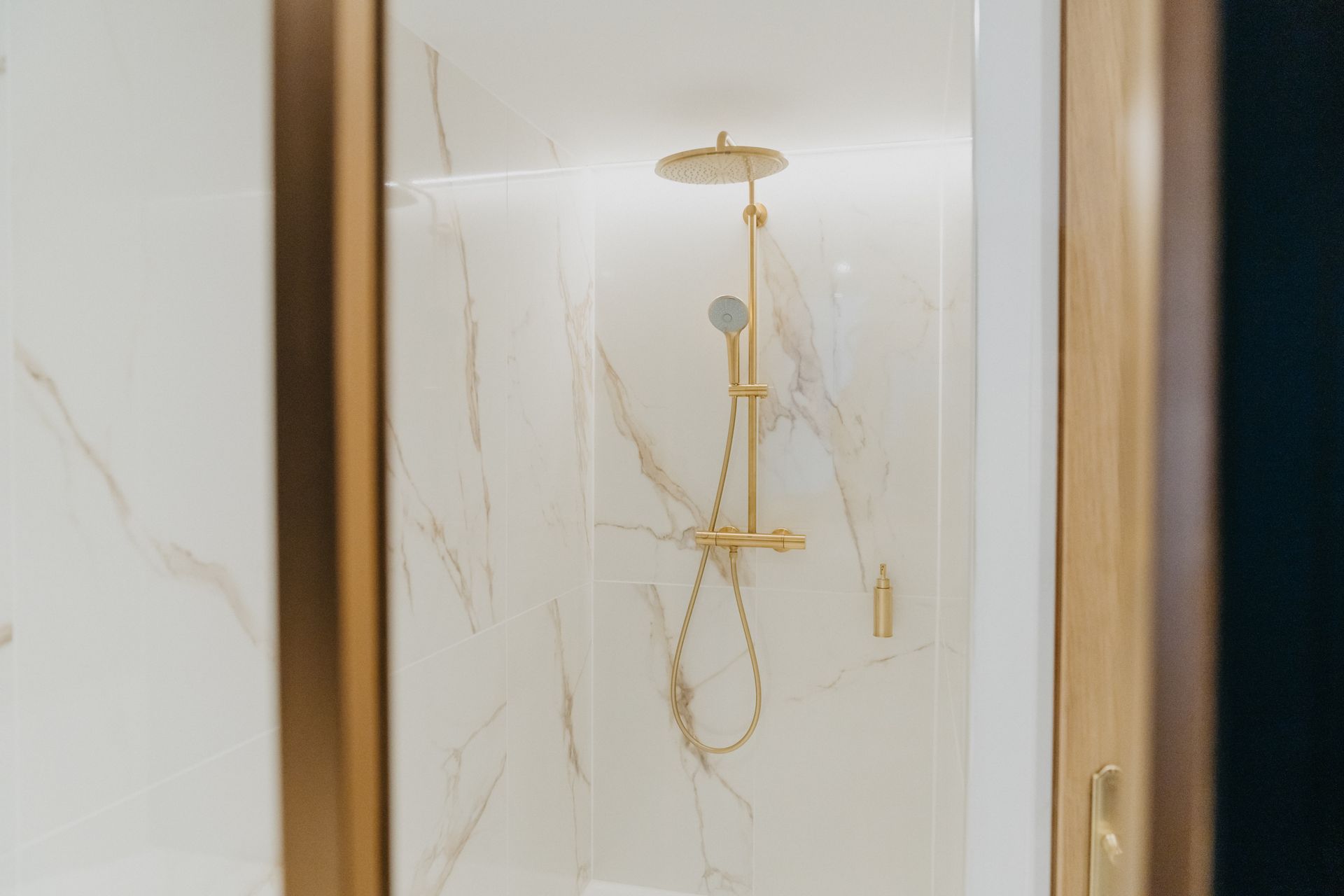 Une salle de bain avec une cabine de douche et un pommeau de douche.