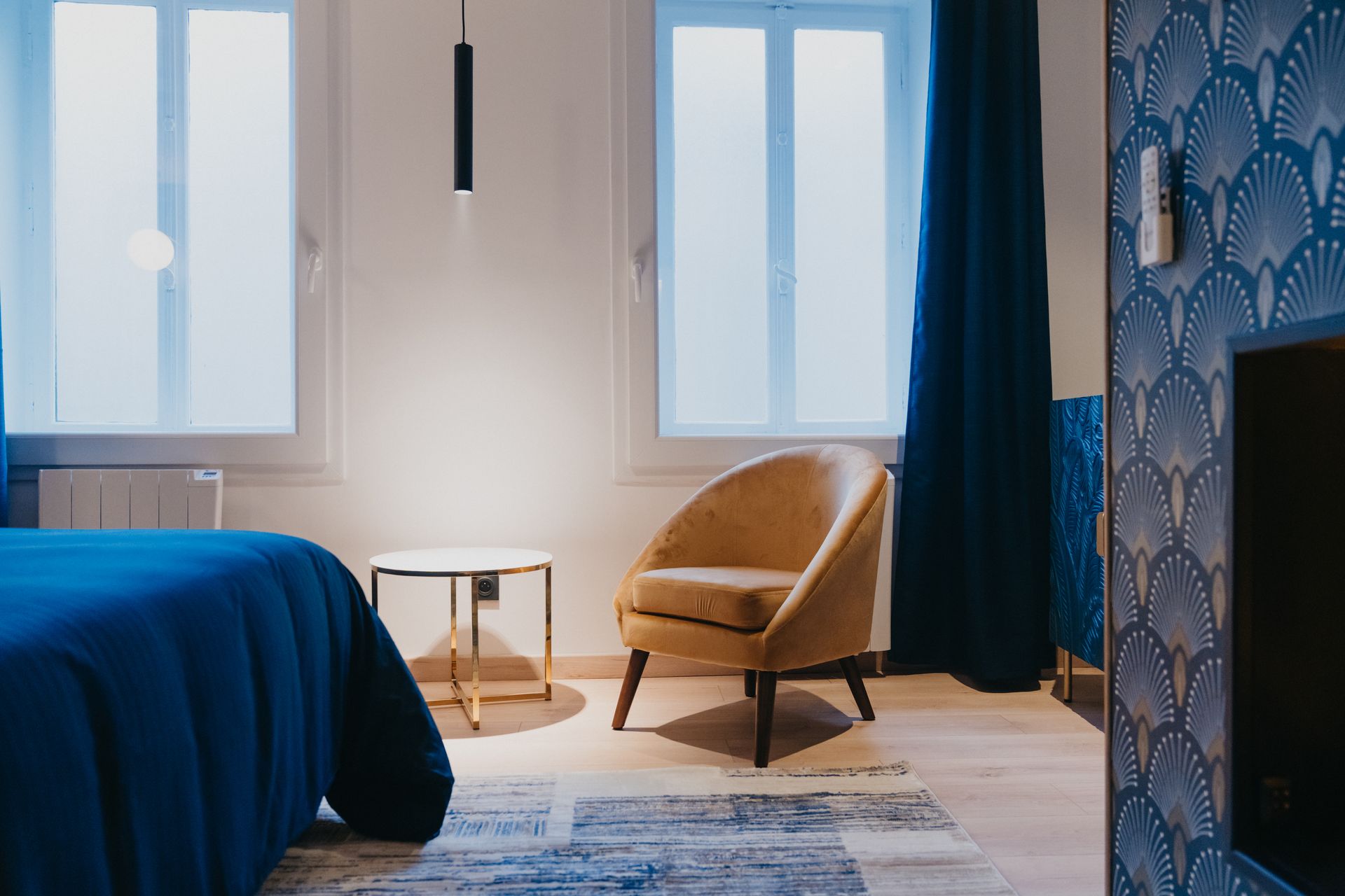 Une chambre avec un lit, une chaise, une table et une fenêtre.