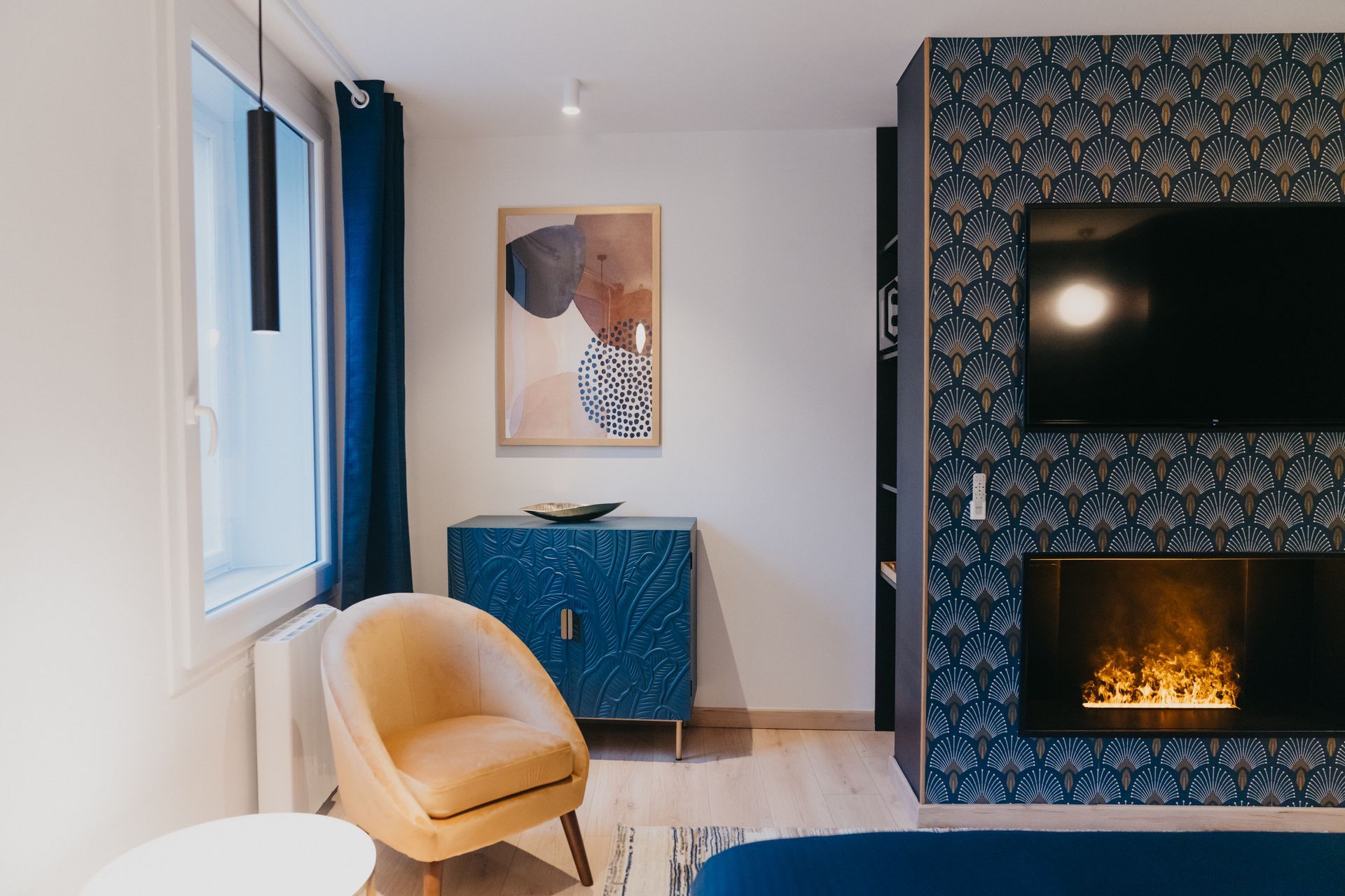 Un salon avec cheminée, fauteuil et télévision.