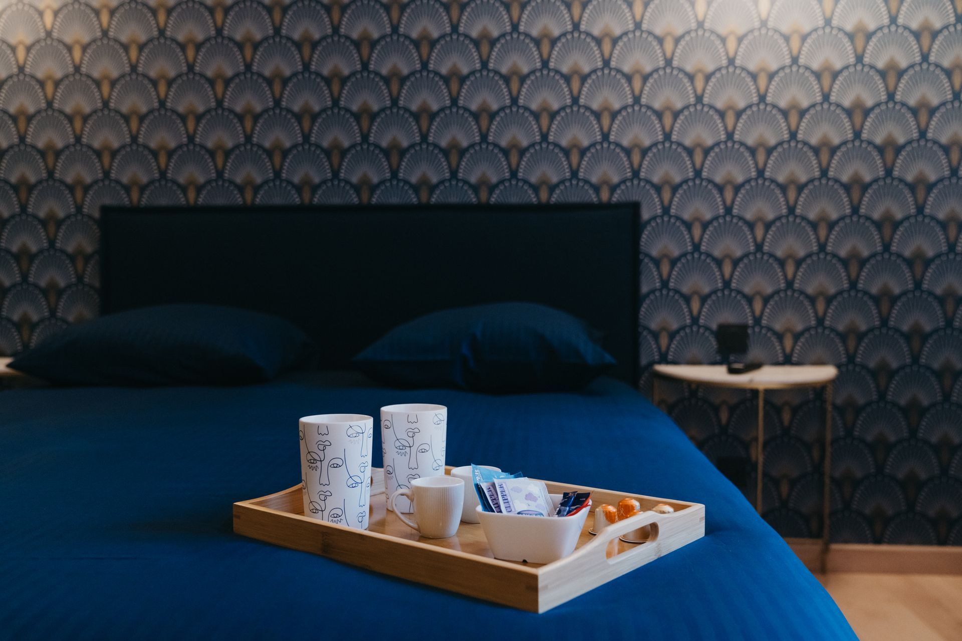 Un lit avec un plateau de nourriture et de boissons dessus.