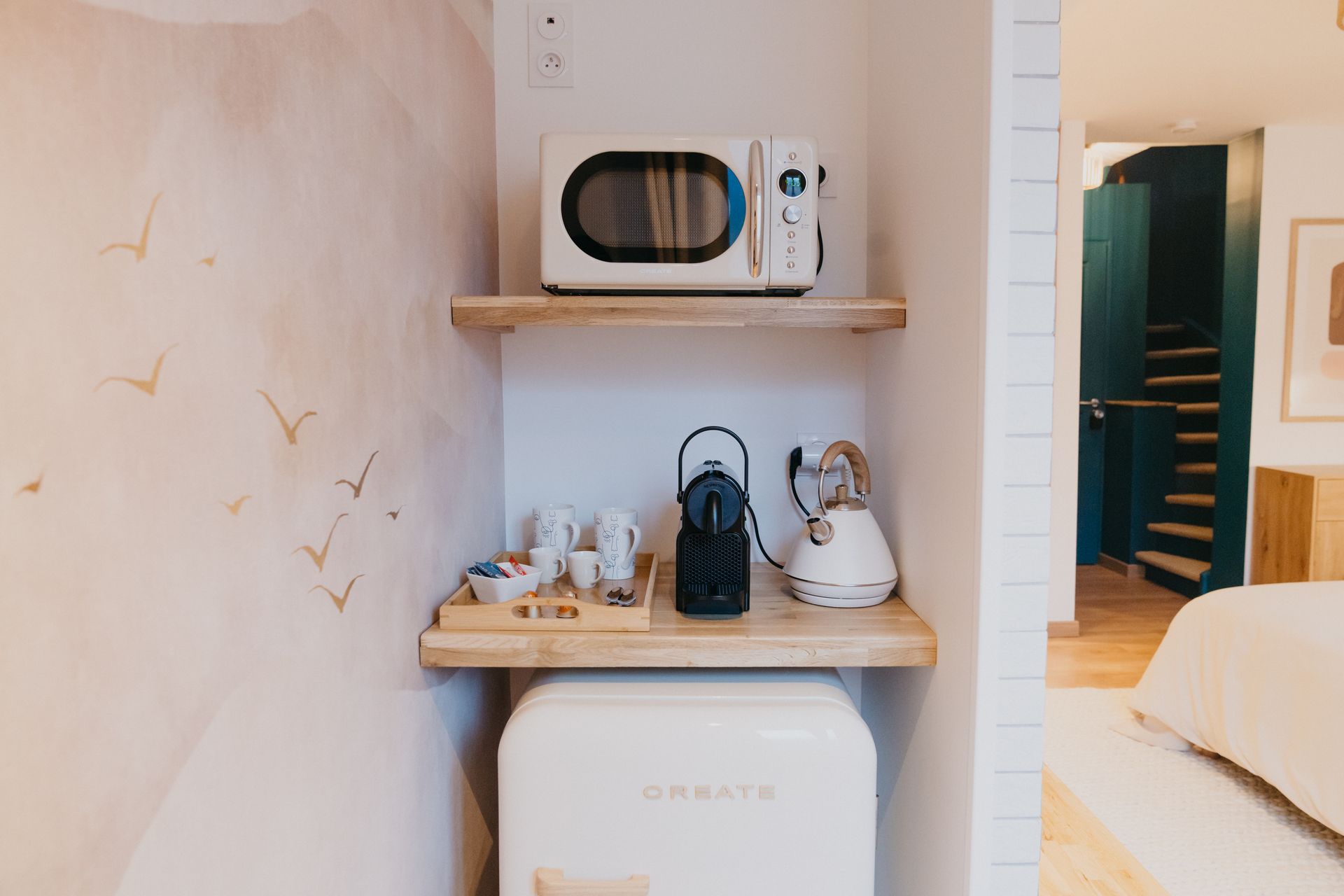 Un micro-ondes et un réfrigérateur sont sur une étagère dans une pièce.