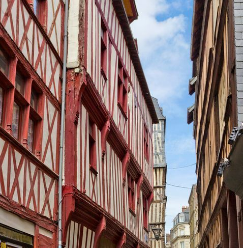 Une ruelle étroite entre deux bâtiments rouges et blancs