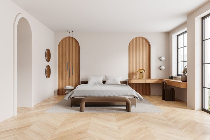 Une chambre avec un lit, un banc, un bureau et une fenêtre.