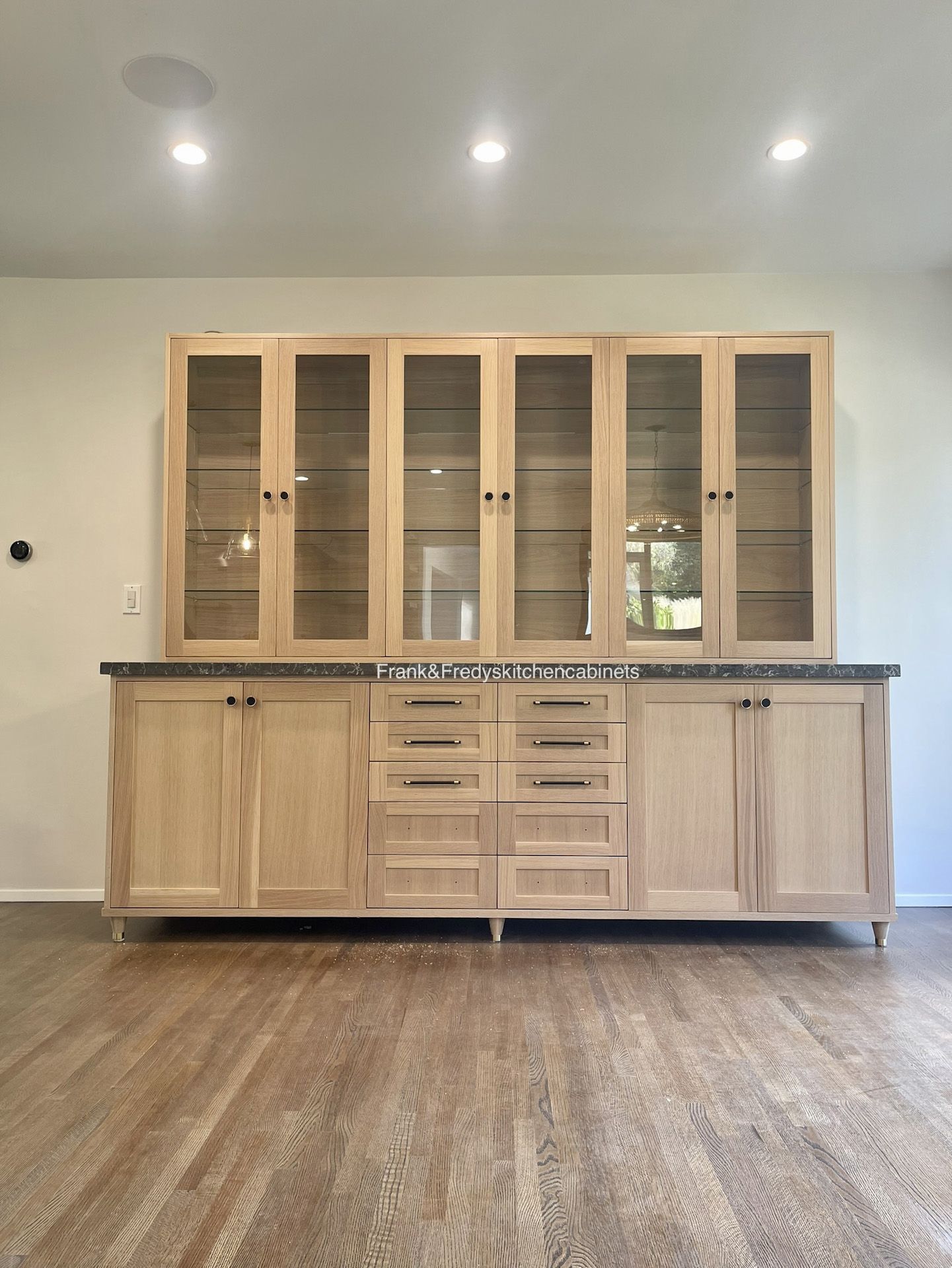 A kitchen with wooden cabinets and glass doors.