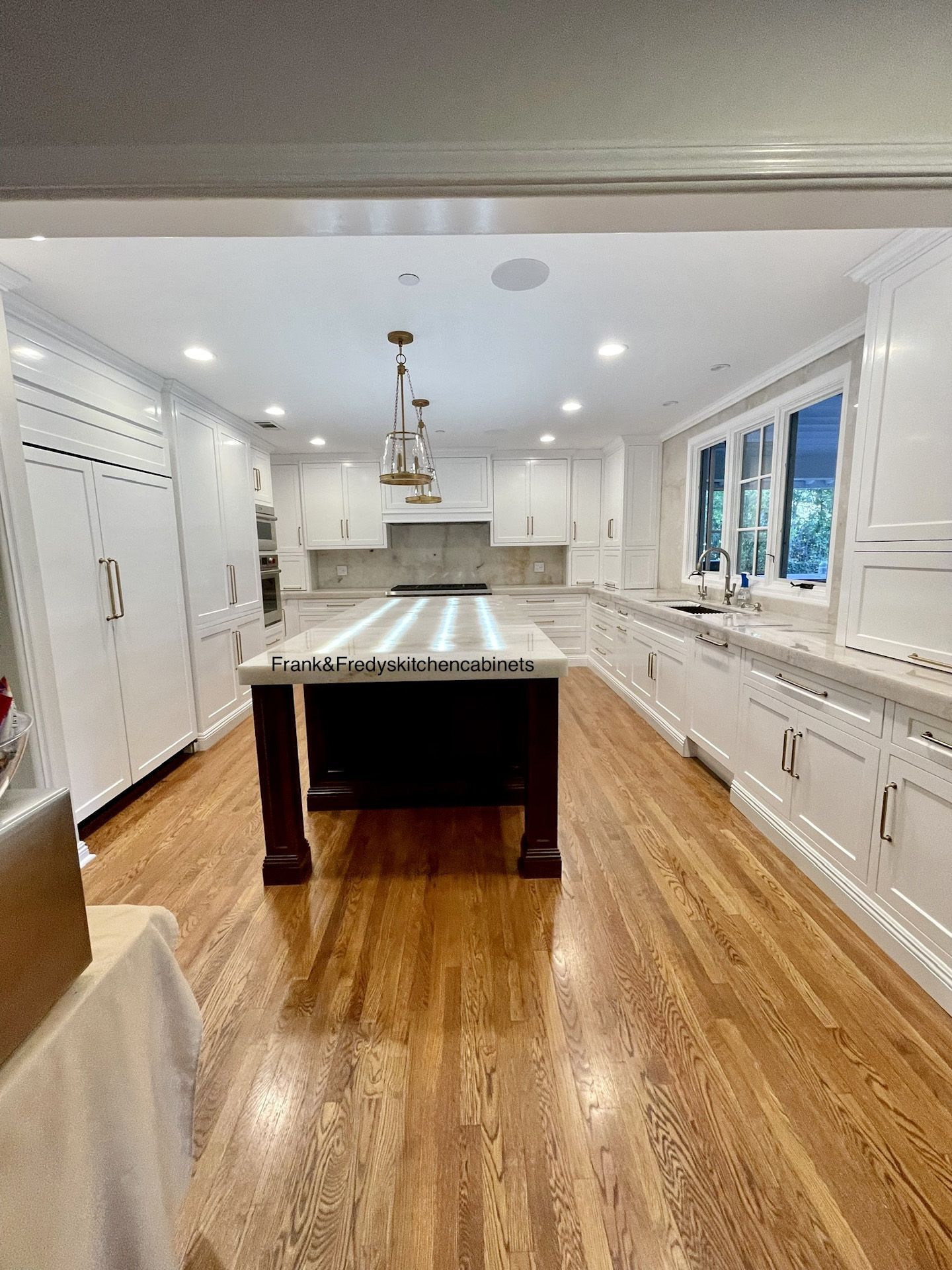 A kitchen with a large island in the middle and hardwood floors.