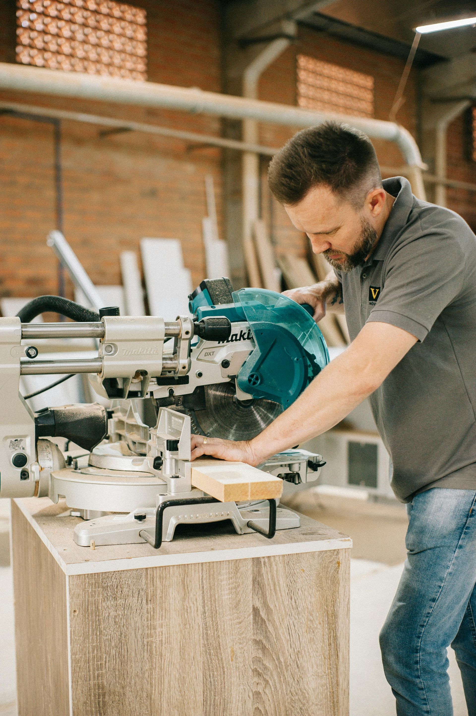 A man is using a circular saw to cut a piece of wood.