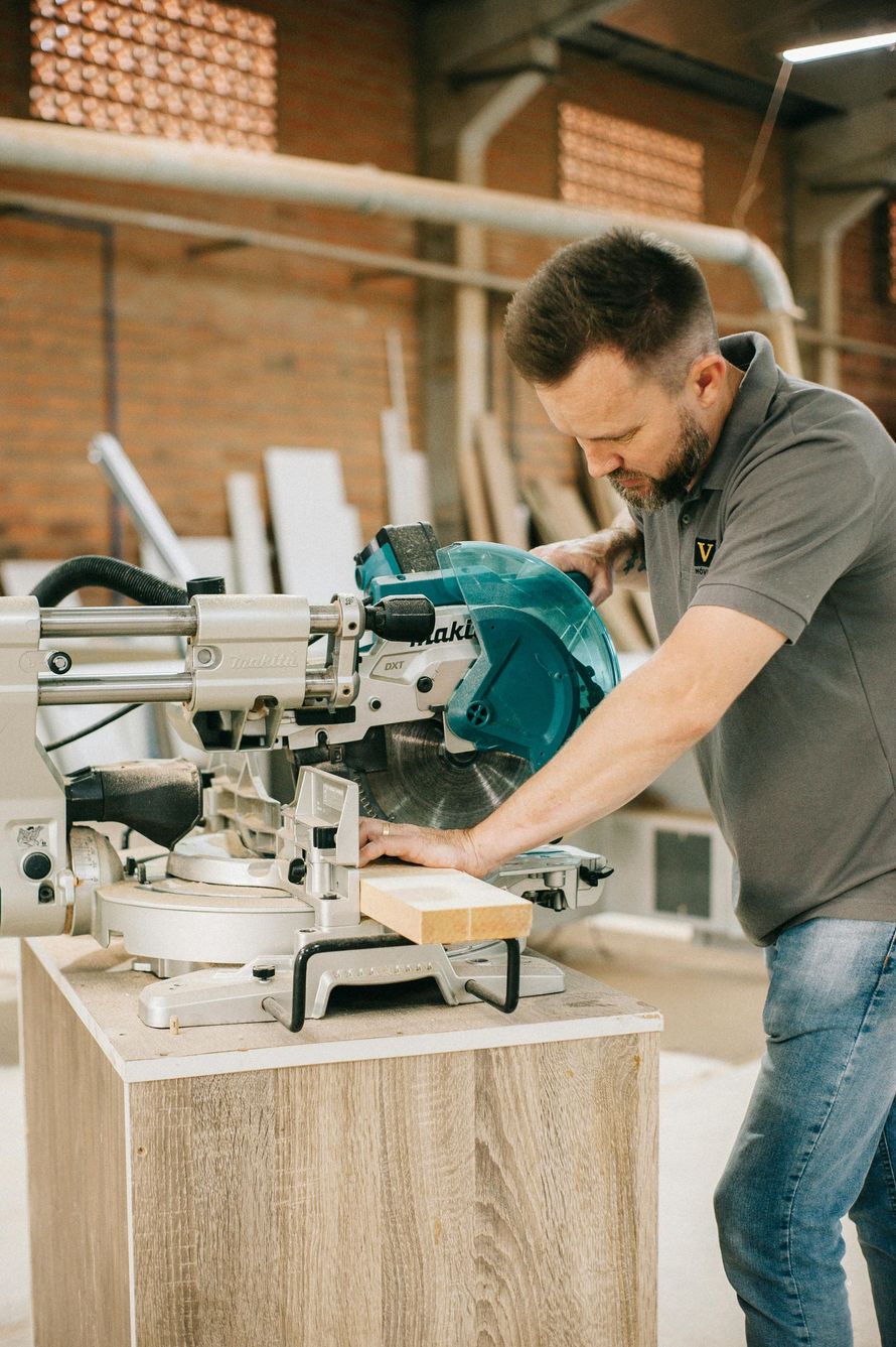 A man is using a circular saw to cut a piece of wood.