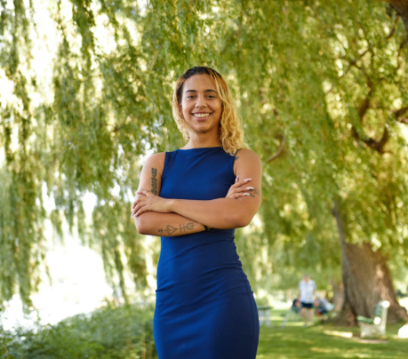 A woman is kneeling down next to a yellow bicycle.
