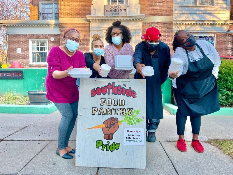 A group of people standing around a sign that says southside food pantry