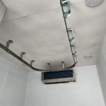 Ceiling-mounted metal rails and hooks in a meat processing trailer for butchers