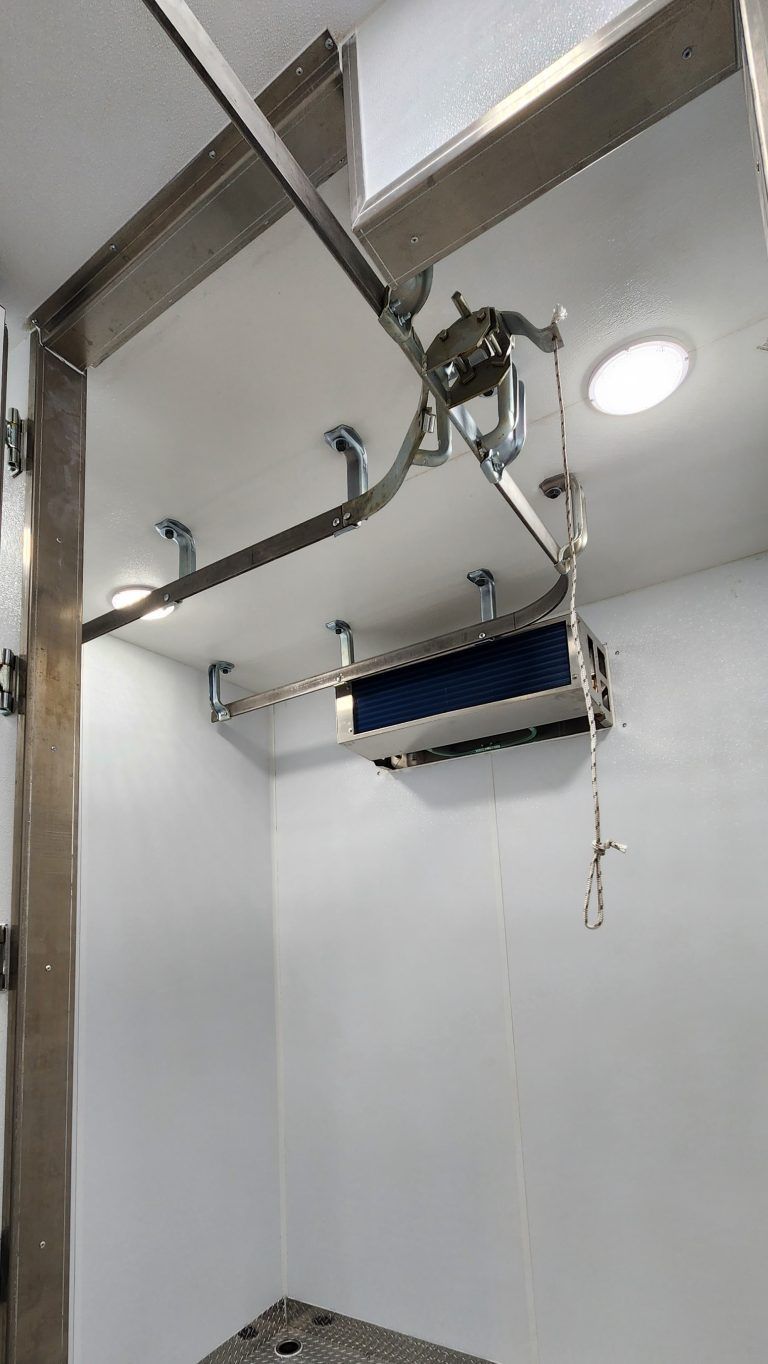 Ceiling-mounted track with motor and hoist for meat processing area in Sentinel trailers
