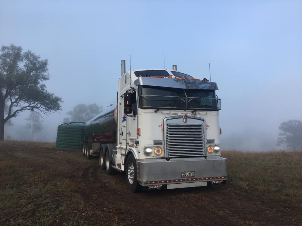 A White Semi Truck Is Parked in A Field on A Foggy Day — Stolzenberg Water Carriers in Chatsworth, QLD